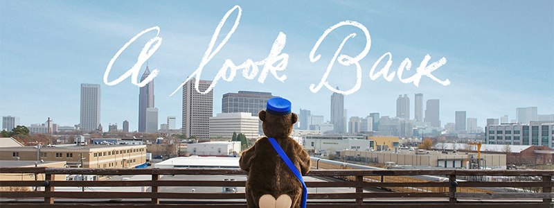 Mailchimp's annual report shows their monkey mascot looking over a city and reads A Look Back