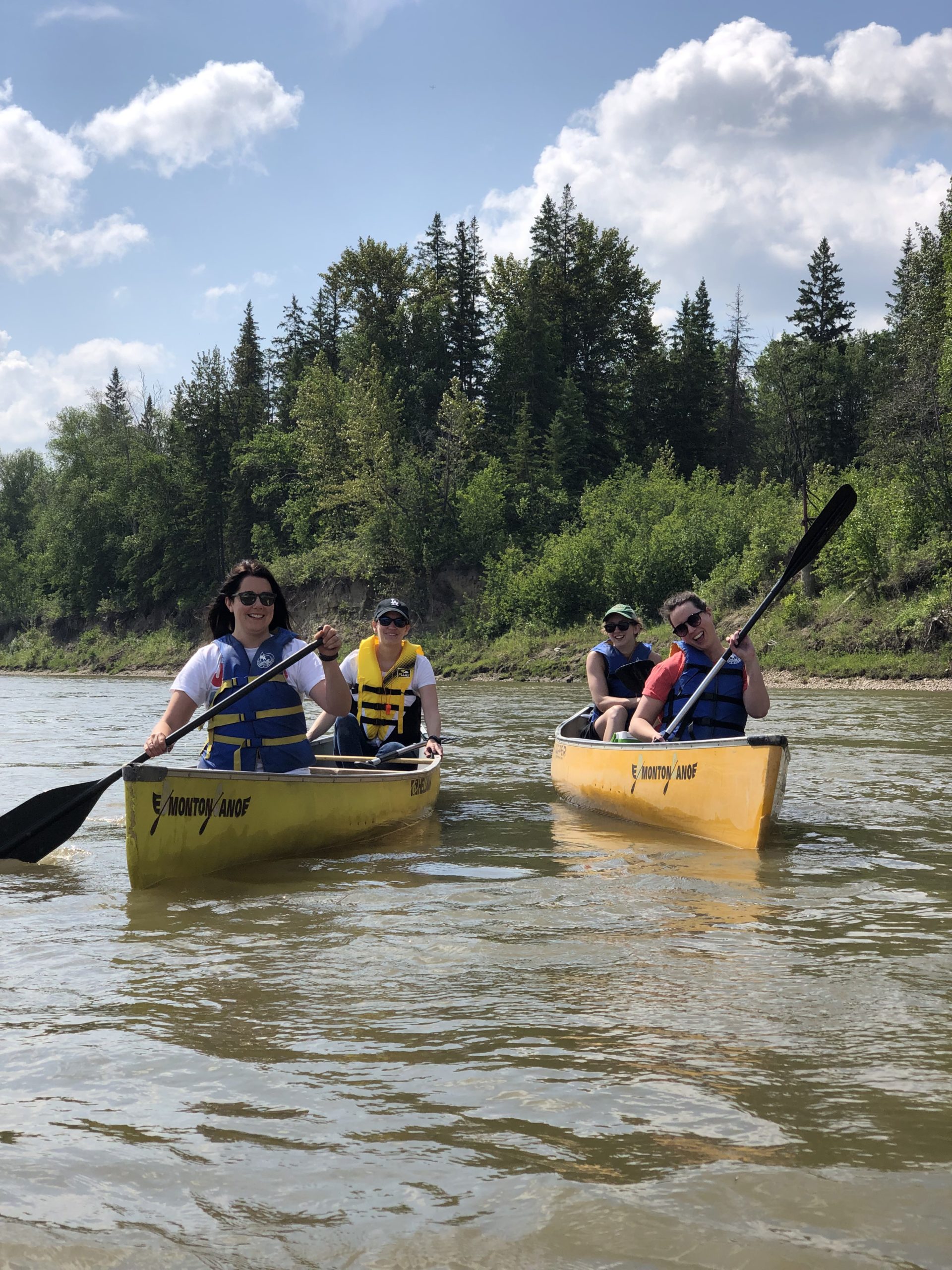 The Kick Point team canoeing down the North Saskatchewan River, four team members split evenly between two yellow canoes