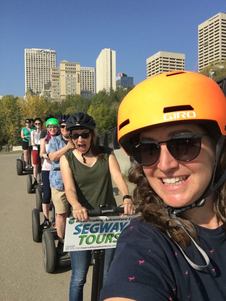Emma taking a selfie with the Kick Point team riding Segways in a line in downtown Edmonton.