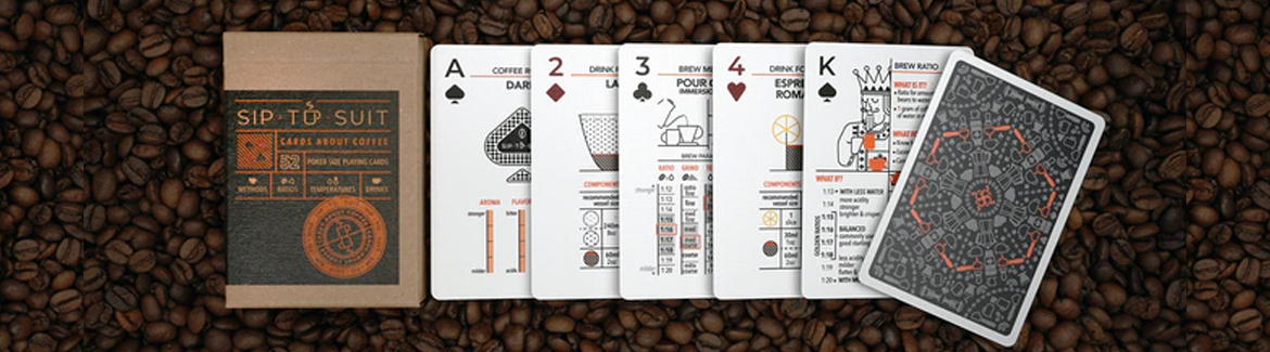 A deck of Sip to Suit Cards About Coffee sits on top of a pile of coffee beans.