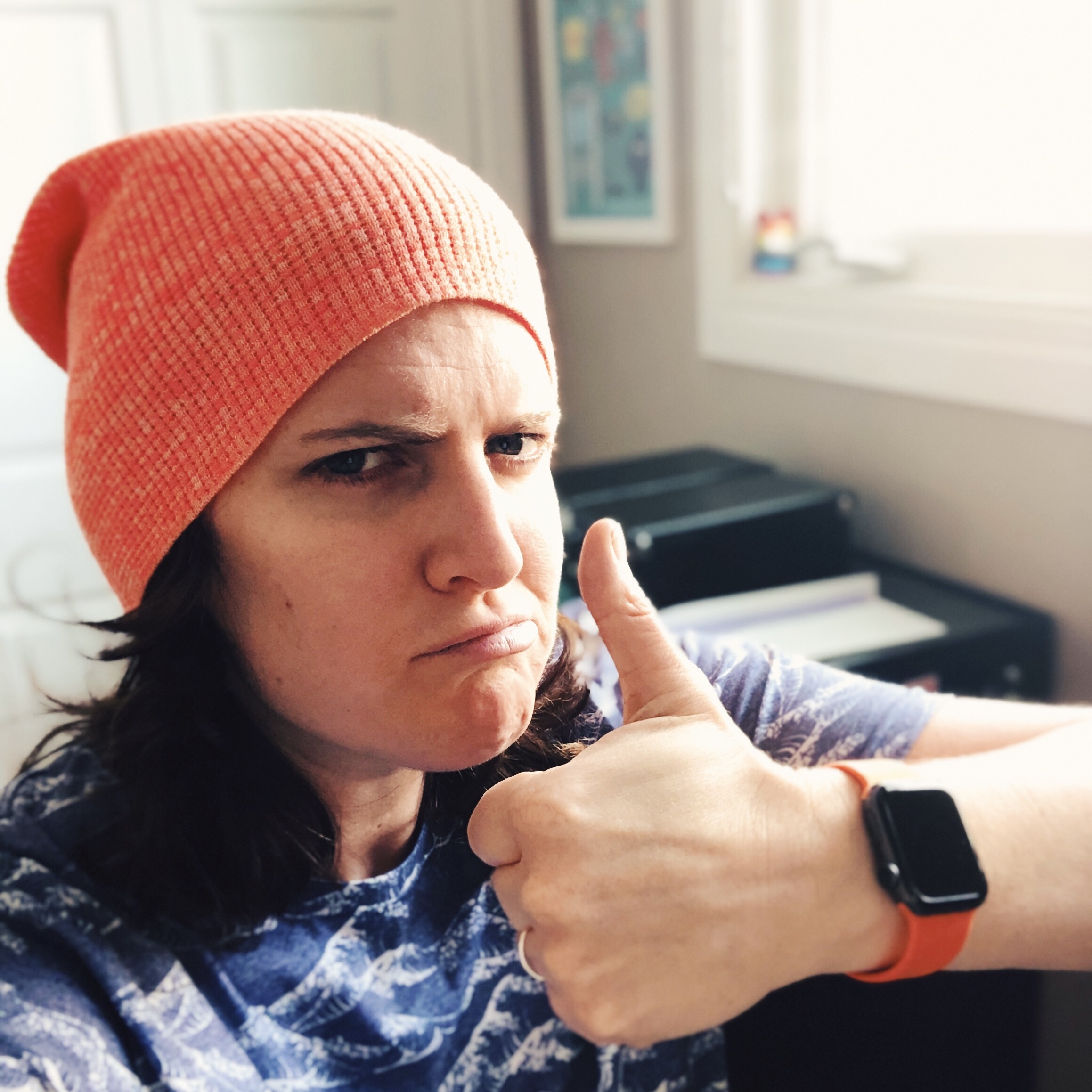 Emma gives the thumbs up sign while wearing a orange toque