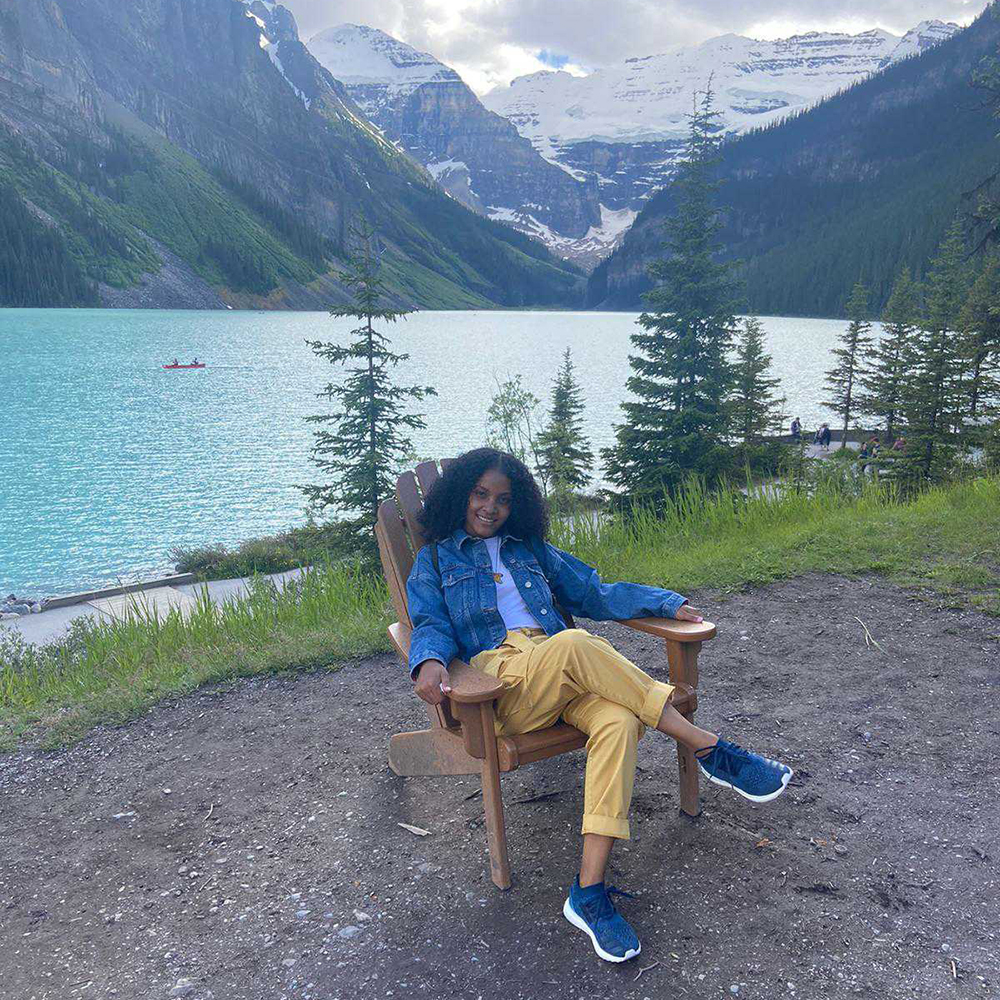 Firdous sits in a chair in front of Lake Louise