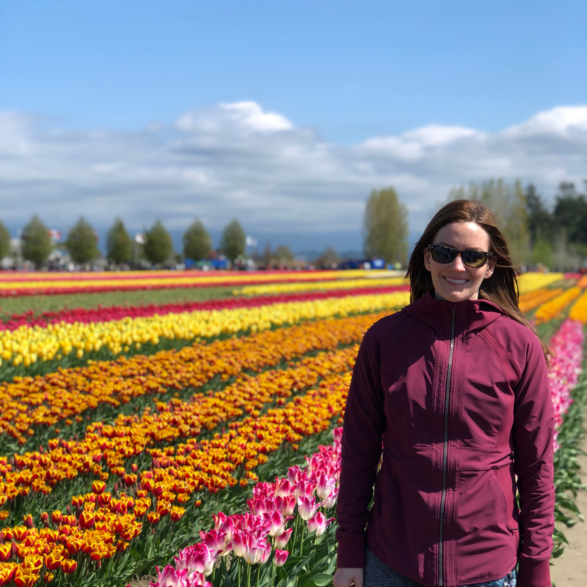 Sarah smiles will standing in a field of colourful tulips