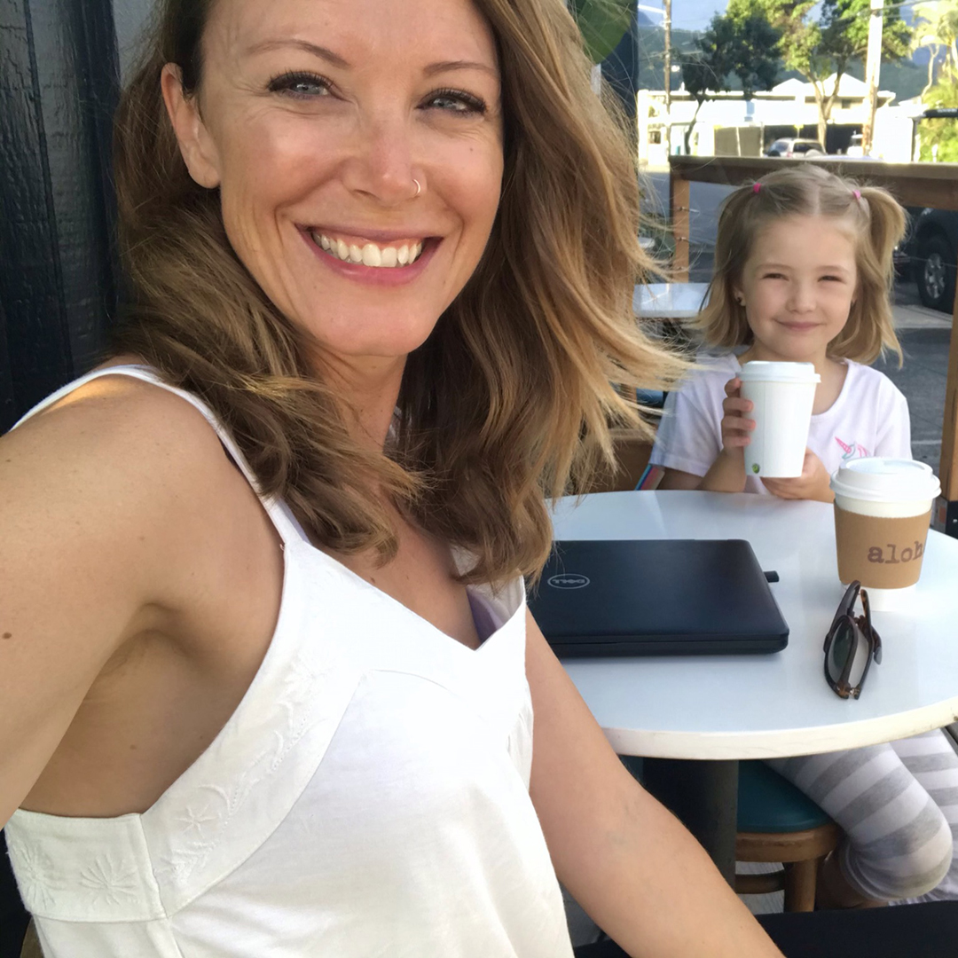Penny and her daughter smile while sitting at a cafe