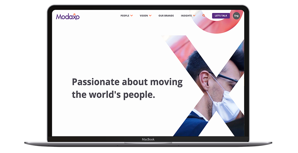 Modaxo's home page on a MacBook. A large heading reads Passionate about moving the world's people