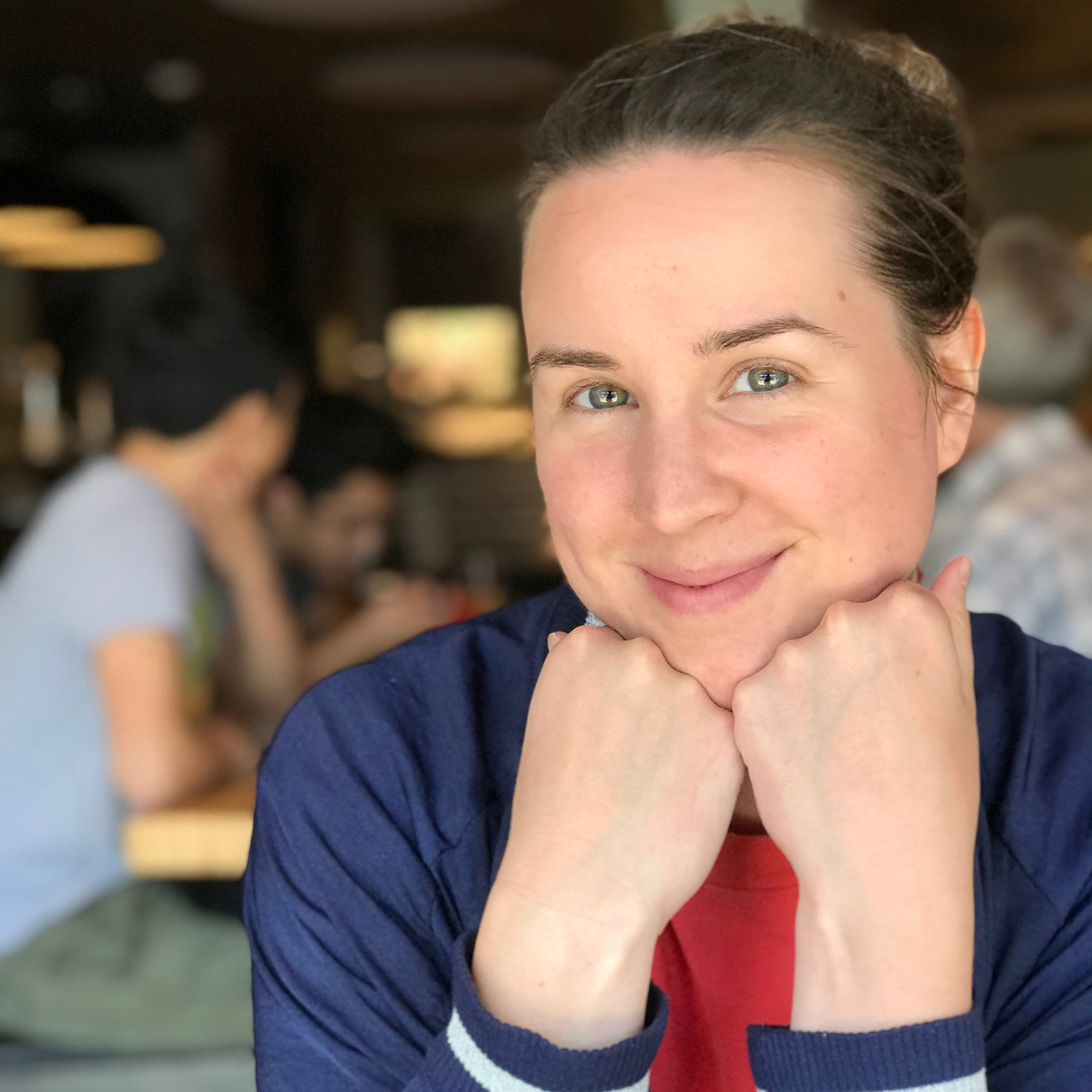 Laura smiling while resting her head on her hands.