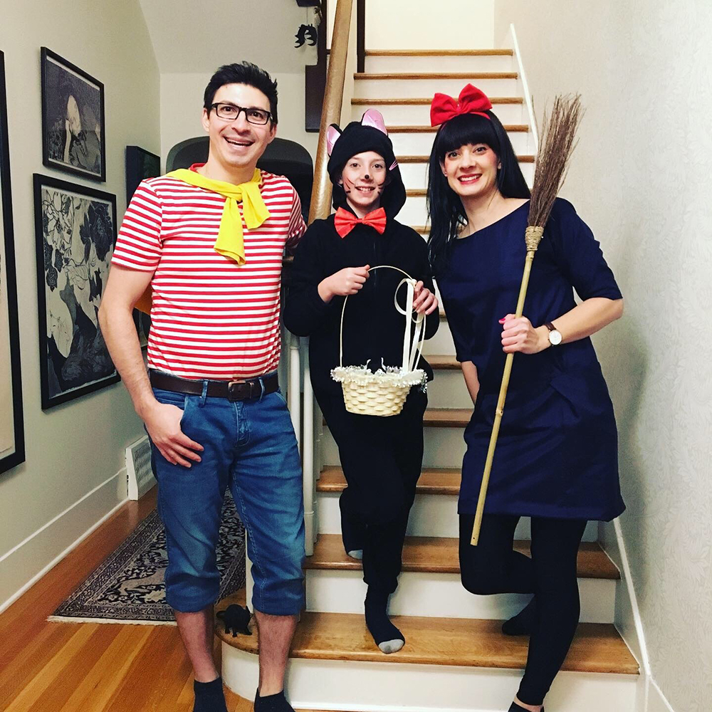 Jessie and her family wear Kiki's Delivery Service halloween costumes while standing on the stairs