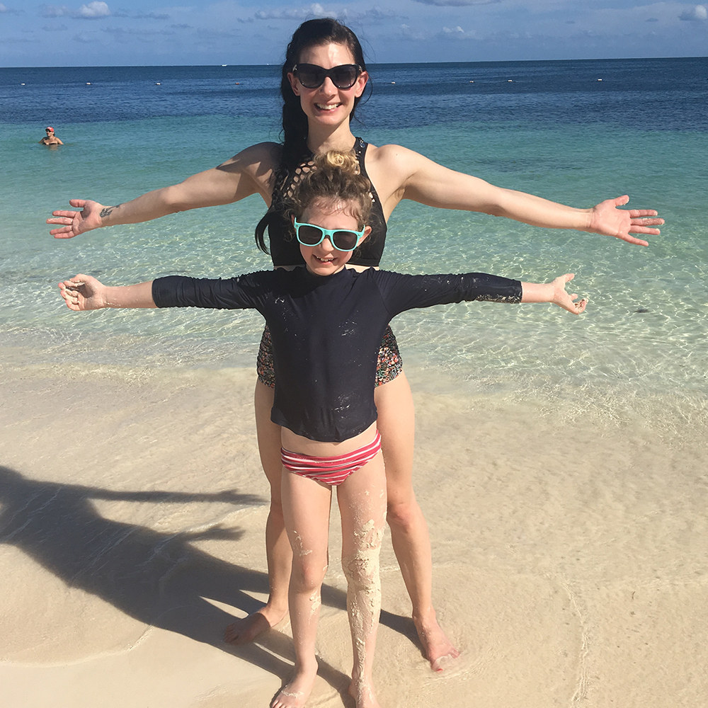 Jessie and her daughter pose in front of the ocean