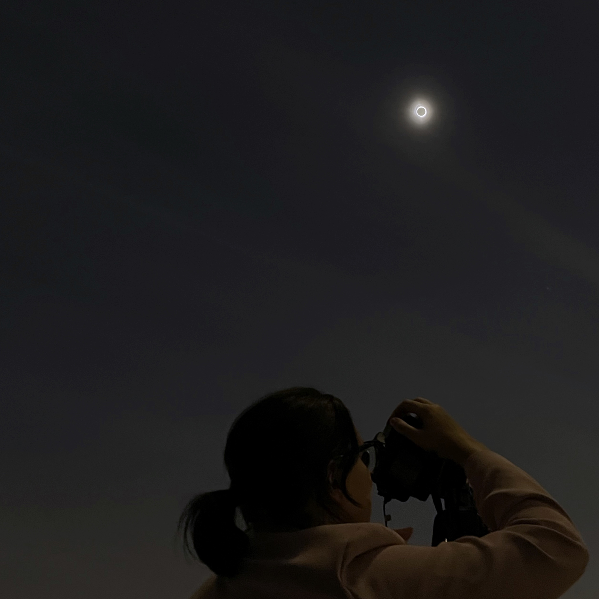 Jamie uses a telescope to watch stars at night. The moon is visible in the dark sky