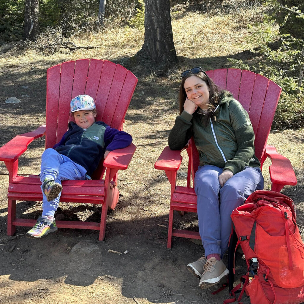Amy and her daughter sitting in red Adirondack chairs