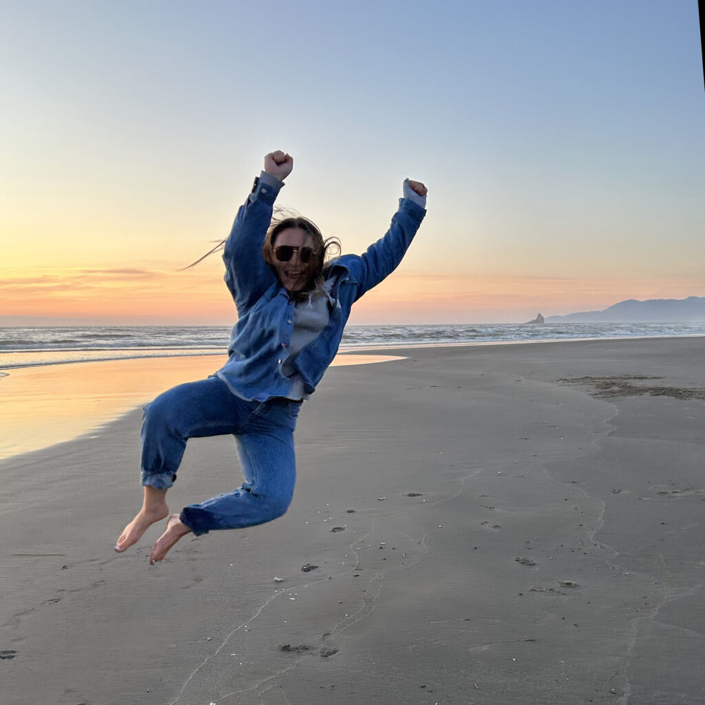 Kyra jumping in the air at the beach