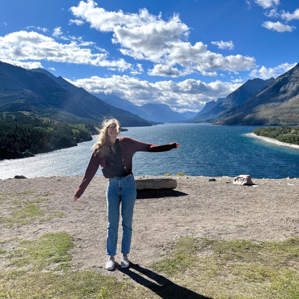 Liz in front of a lake and mountains